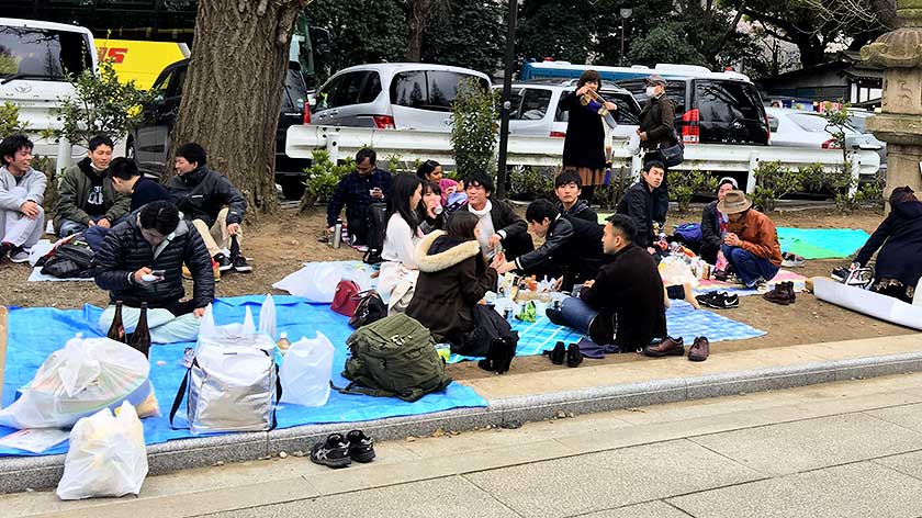 A typical hanami party sitting on a tarpaulin