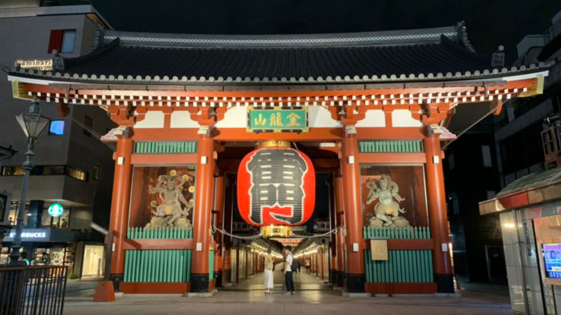 Night view of the Kaminarimon Gate at Senso-ji Temple in Tokyo, Japan, with its iconic large red lantern and ornate statues.