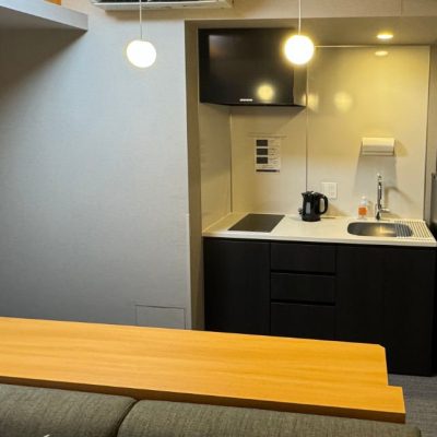 The kitchen area of the Two Bedroom Theater Suite comes with an IH range, large sing and counter, mid-sized refrigerator and microwave. A bar-type table can seat 4 people.
